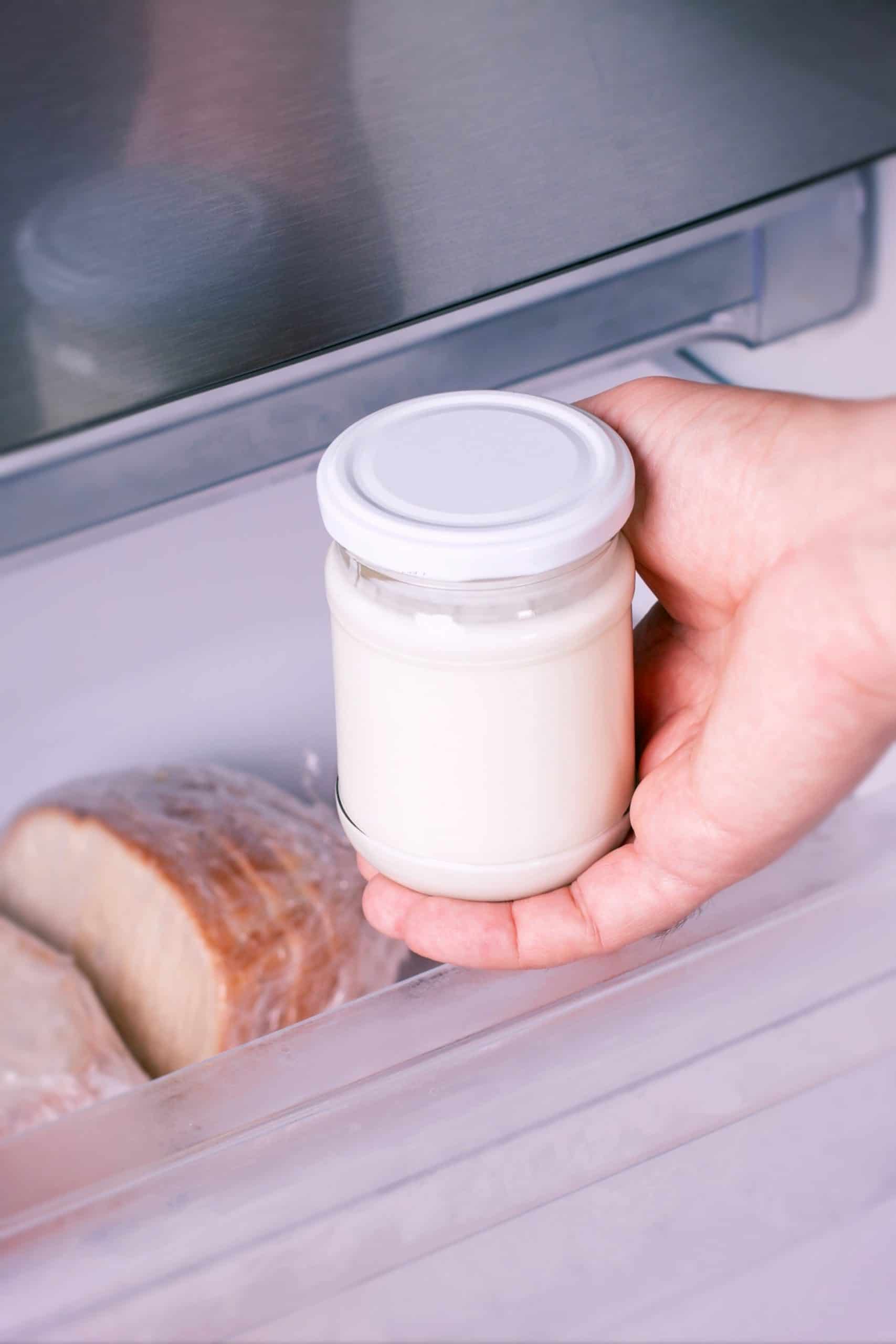 hand putting Greek Yogurt in freezer