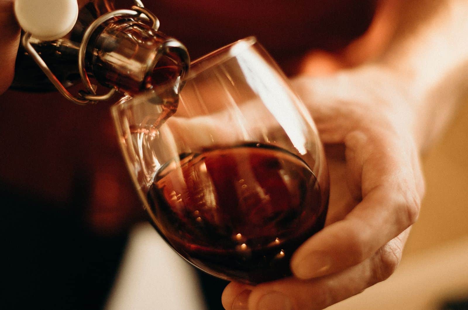 pouring red wine in glass