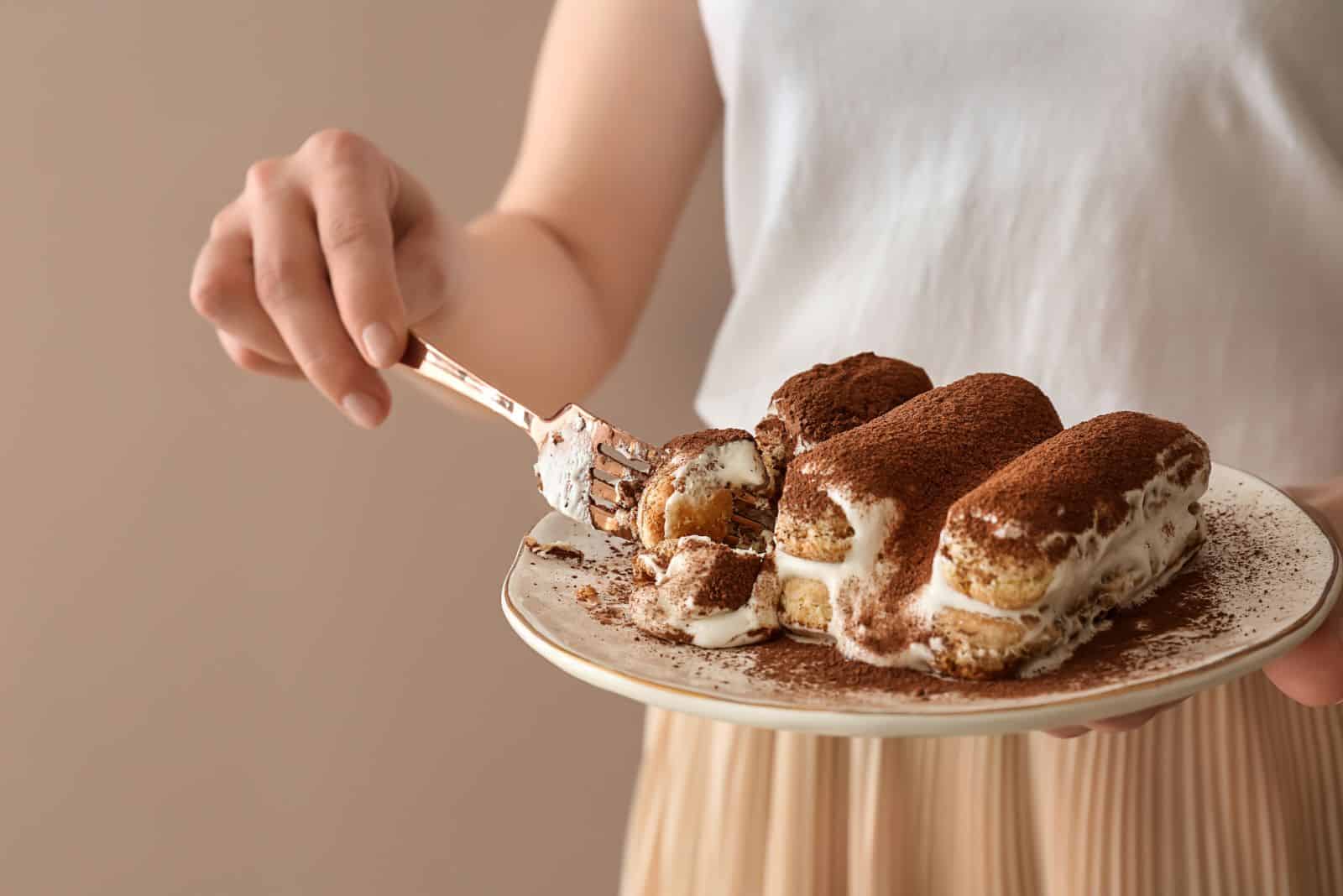 la mujer está comiendo tiramisú