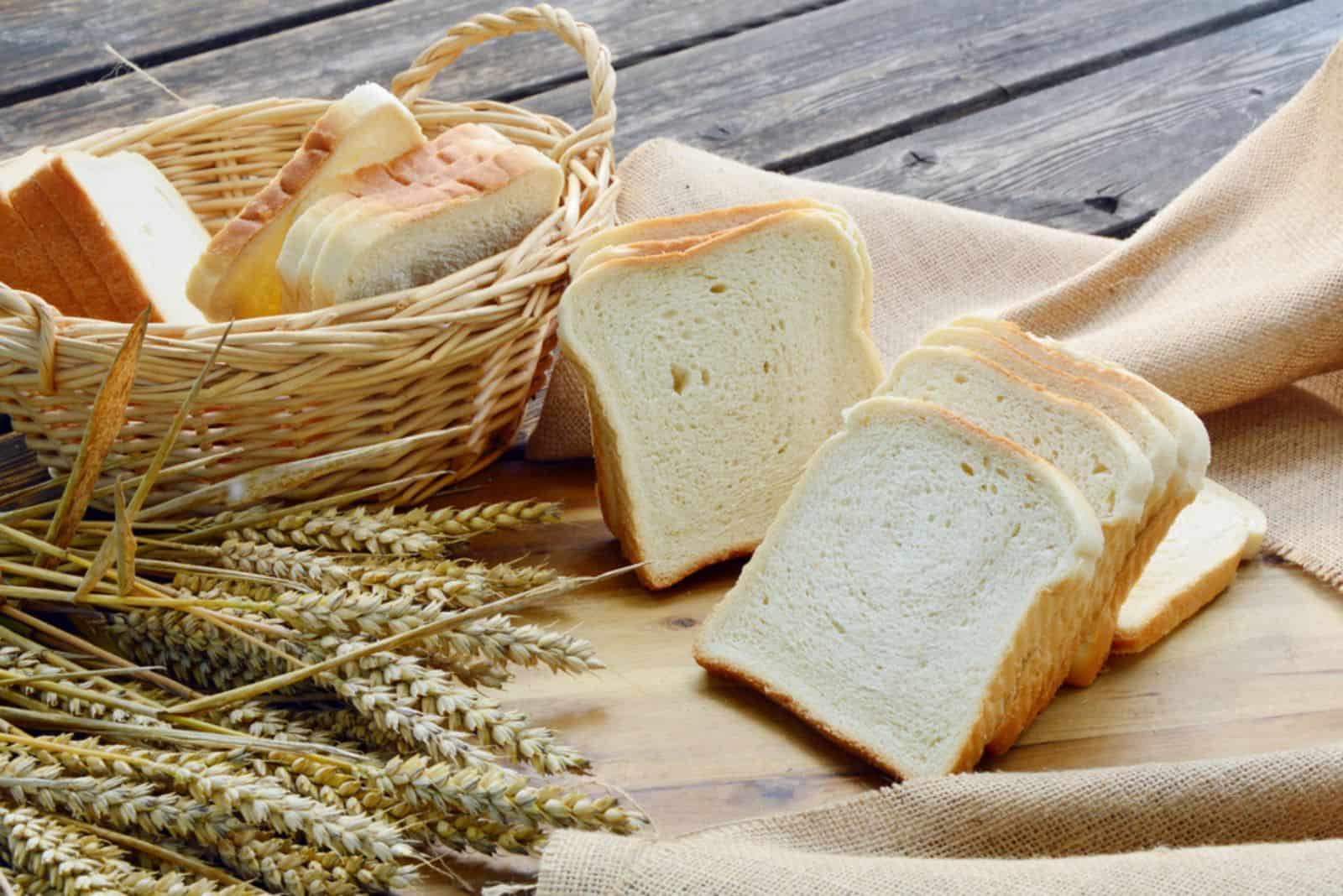 white bread or sliced bread in the basket on wooden floor with sack cloths