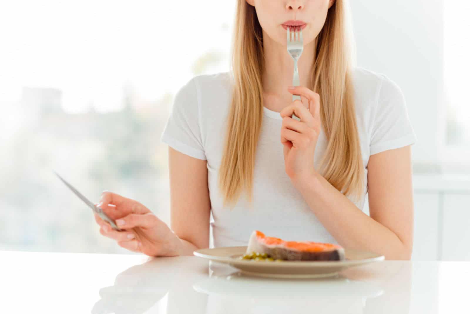 woman eating salmon fillet