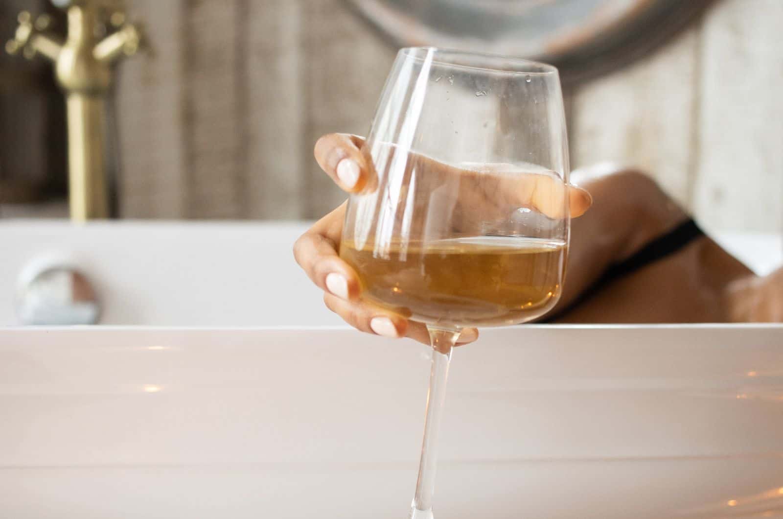 mujer con un vaso de vino blanco en la mano