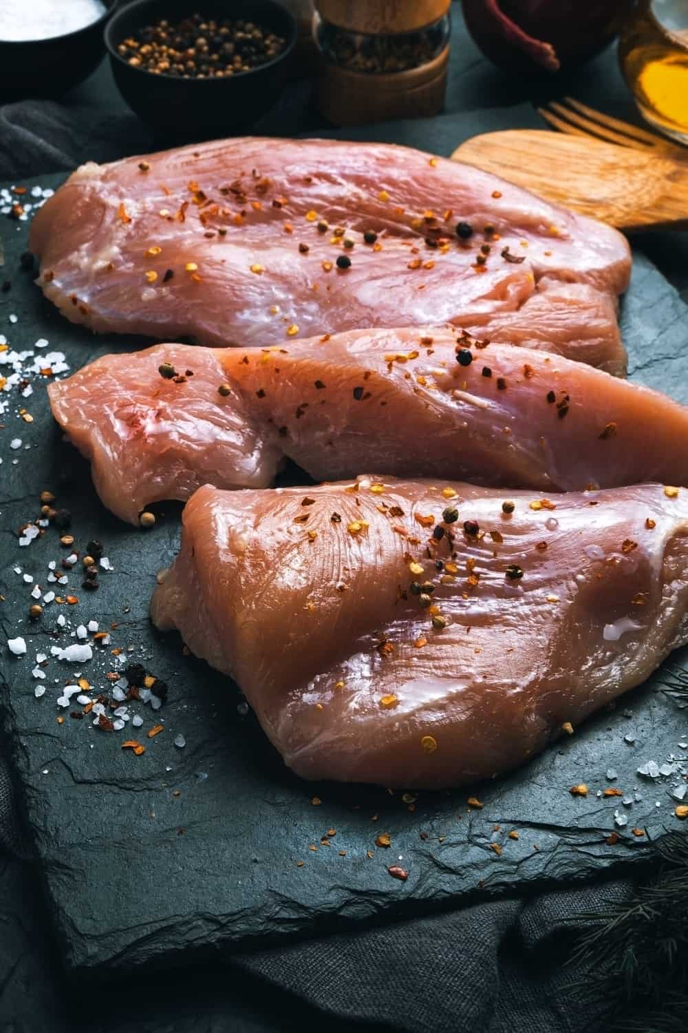 Petti di pollo su lavagna nera