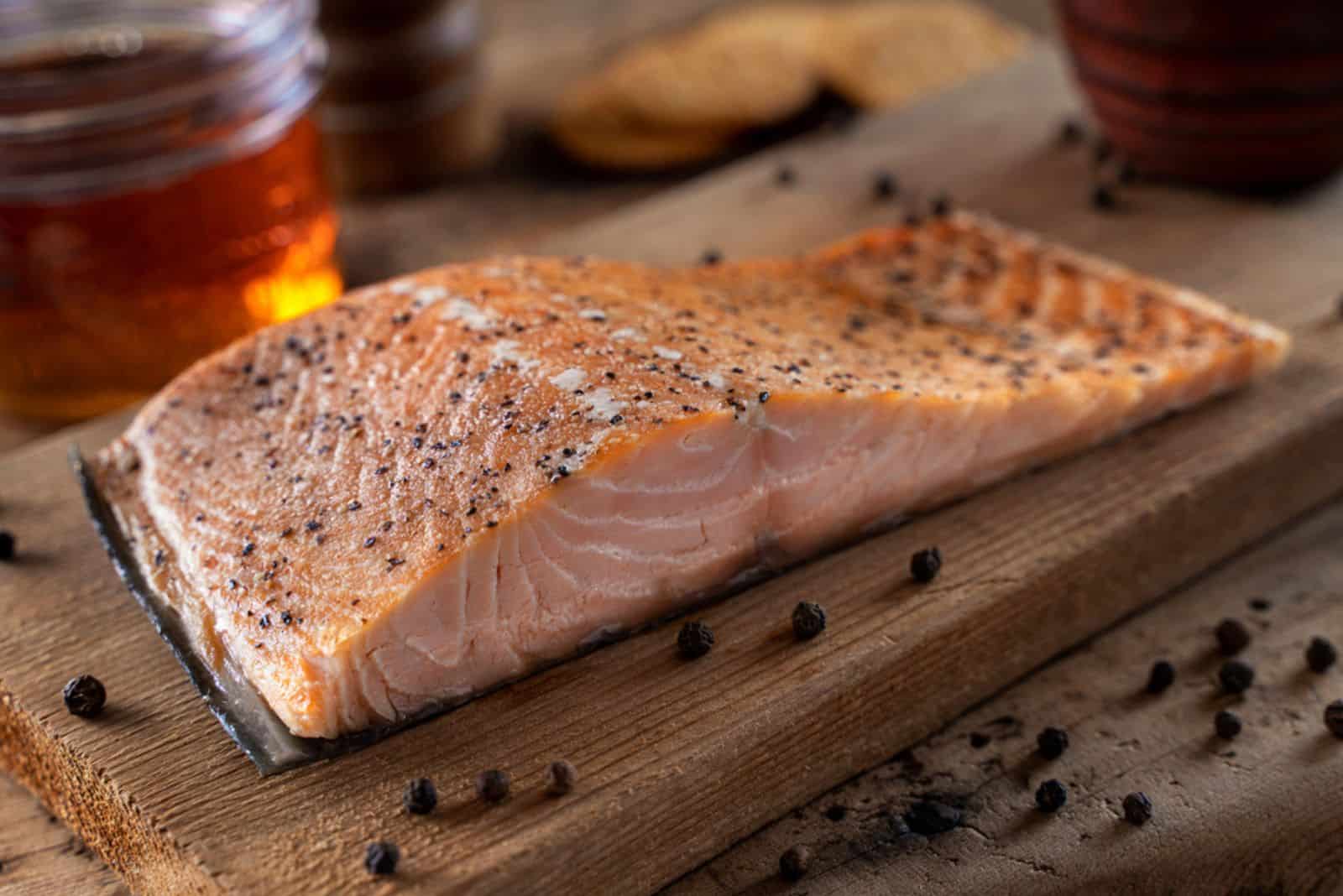 Delicious maple and cracked black pepper hot smoked salmon on a cedar plank
