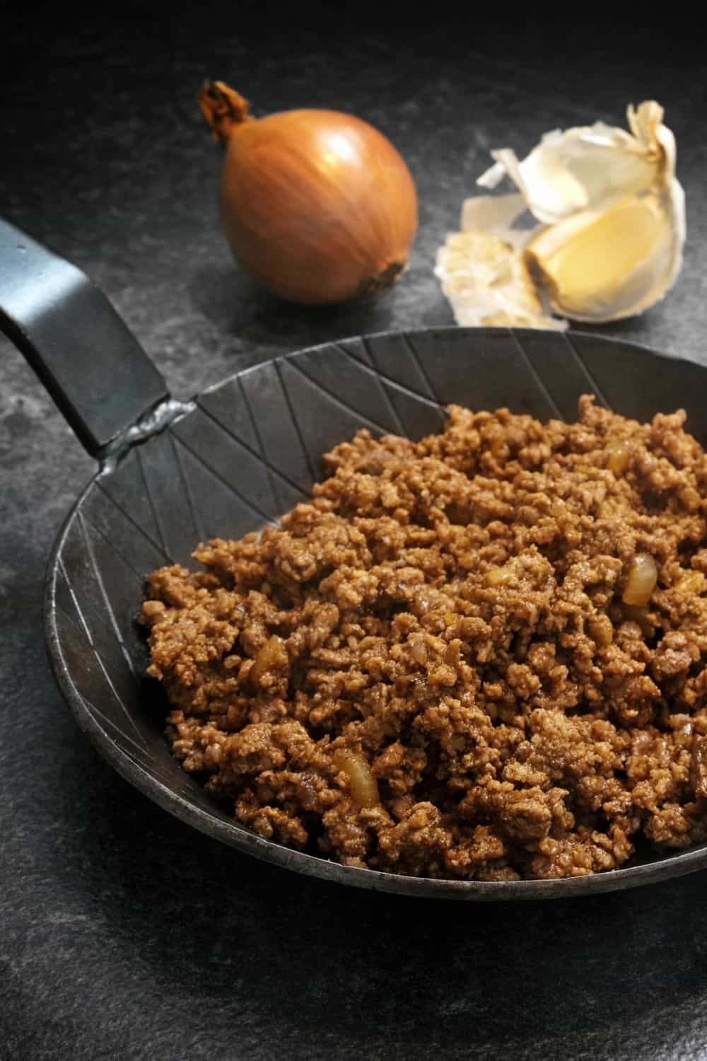 Ground Beef in pan with onion in background