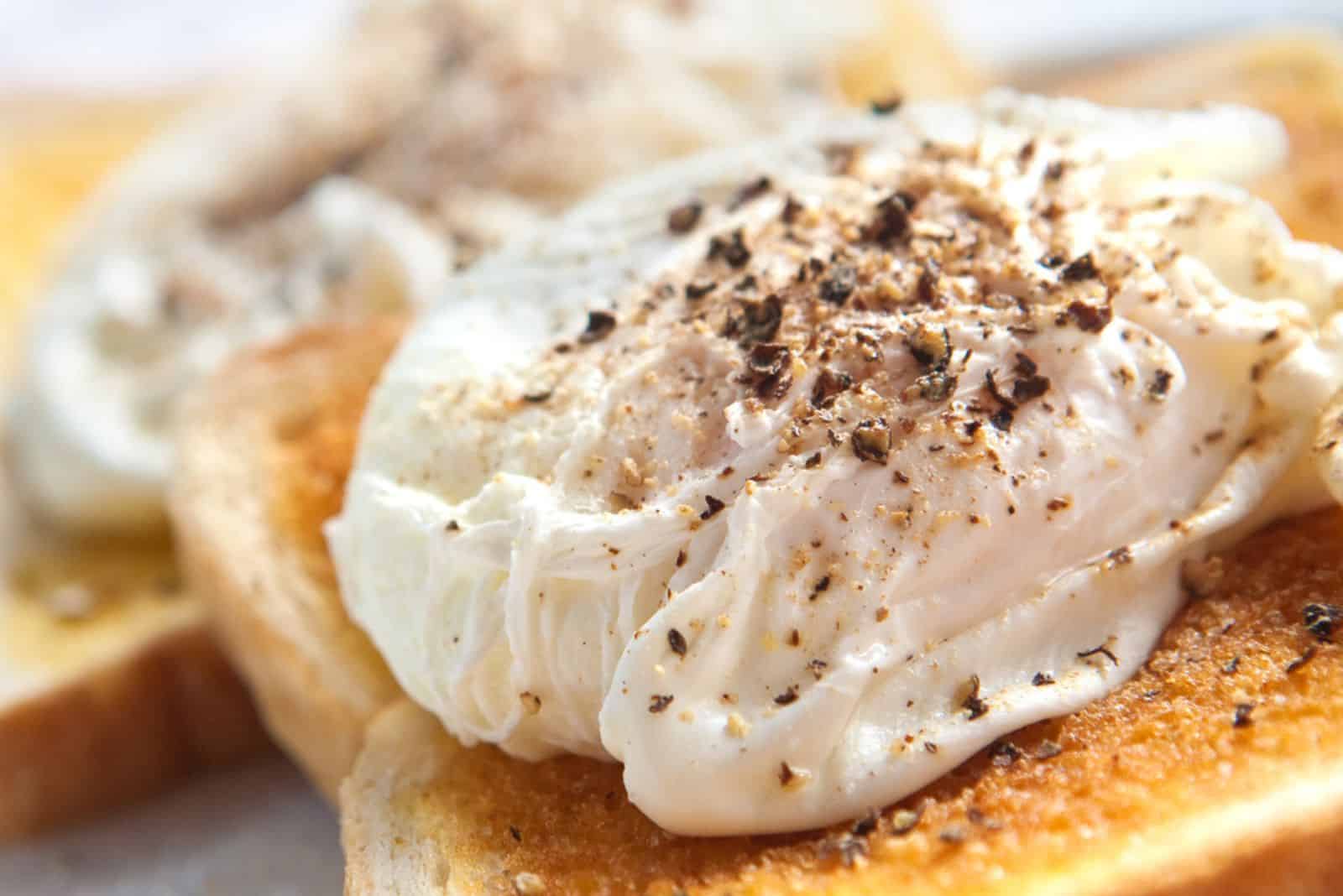 Two delicious poached egg on toast with freshly cracked black pepper
