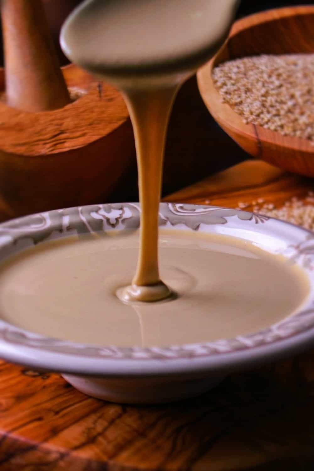 pouring Tahini from spoon into a plate