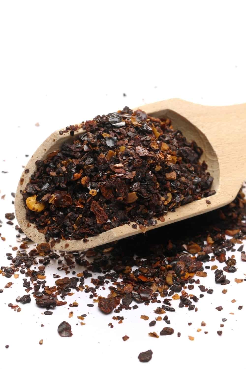 Aromatic spicy chili pepper flakes, dry ancho chili pile with wooden spoon