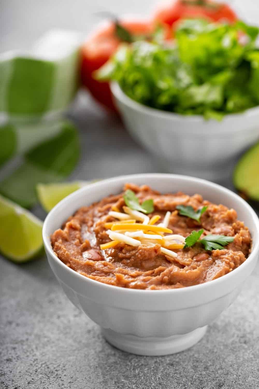 refried beans in a bowl with lime in background