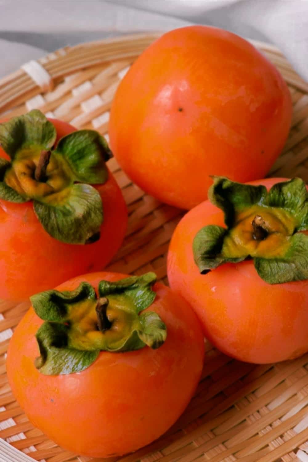 ripe persimmon in a wicker bowl