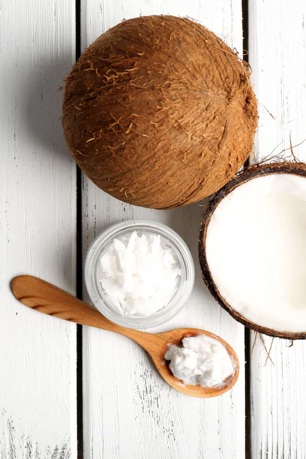 top view of coconut oil with spoon, and coconuts
