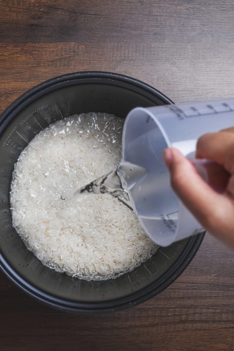 2 Cups Of Rice How Much Water Recipe Answer   Top View Of Person Pouring Water Over Rice 768x1152 