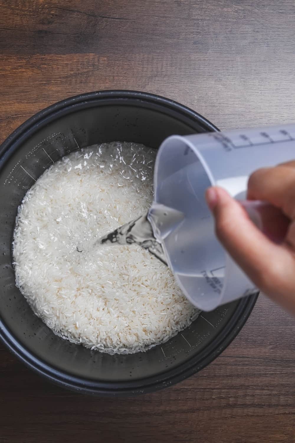 top view of person pouring water over rice
