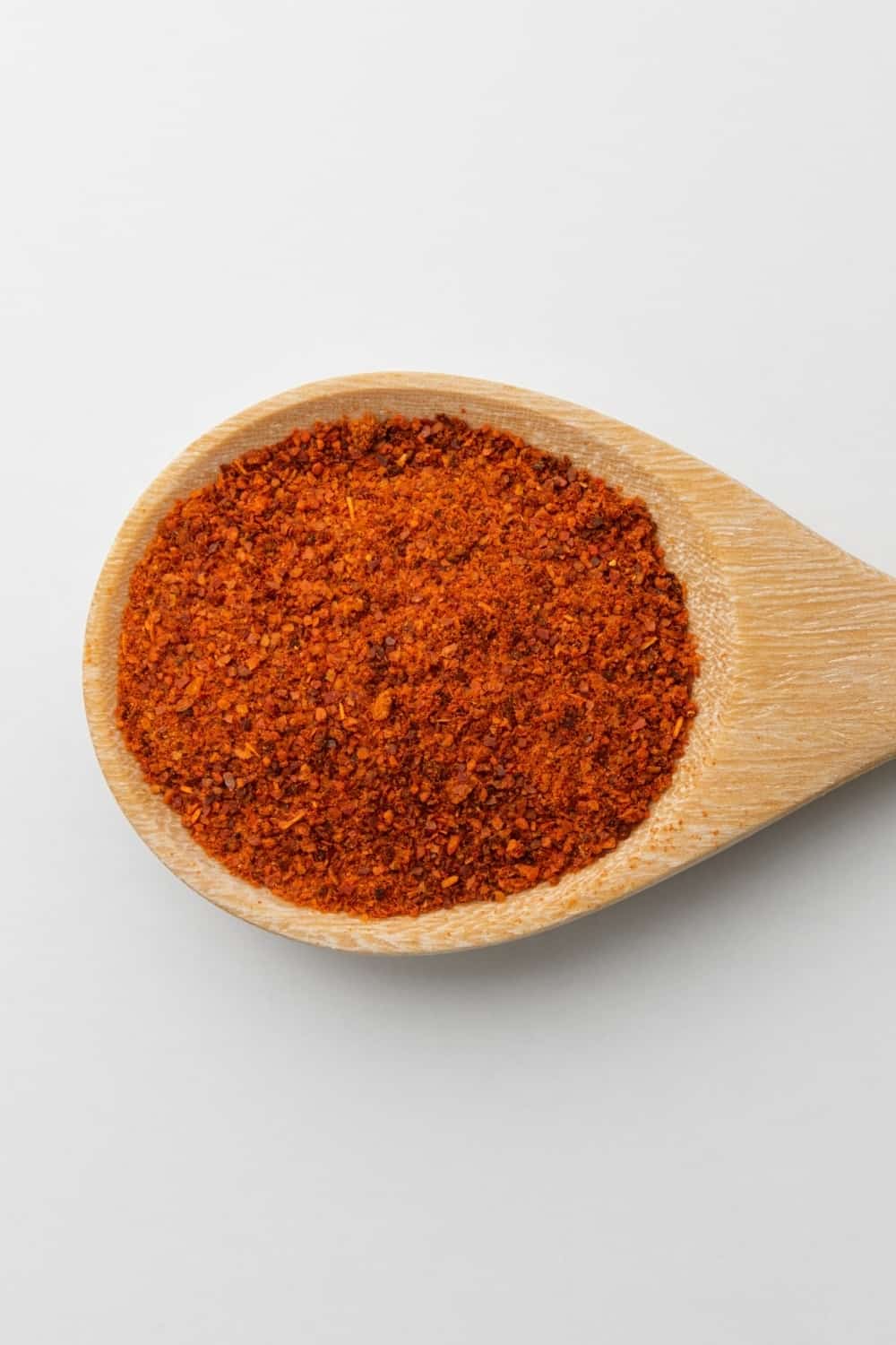 cuillère en bois de paprika sur fond blanc