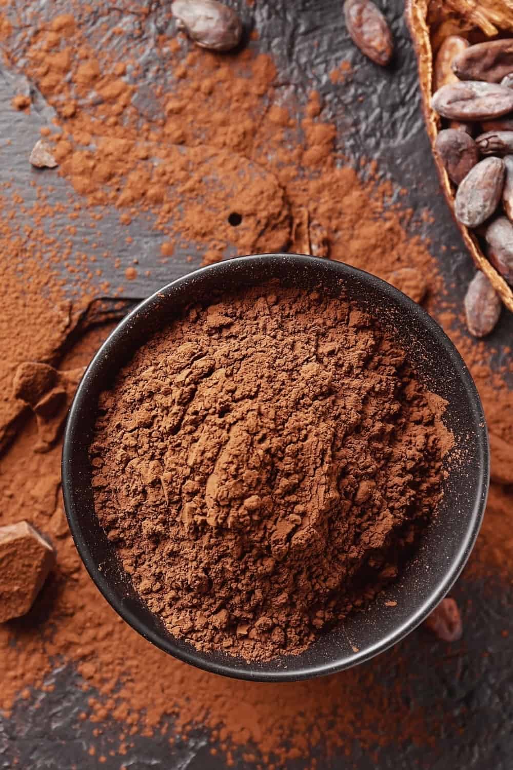 Composición con cacao en polvo, habas y chocolate sobre la mesa