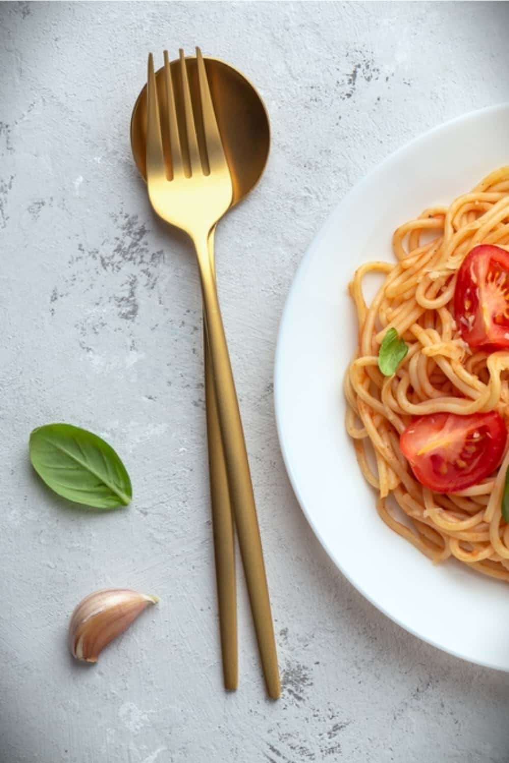 eine Gabel und ein Löffel mit Spaghetti auf einem Teller