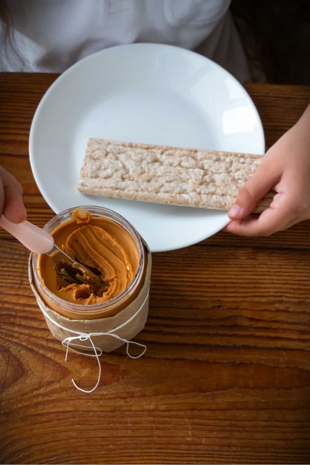 bambina che mangia il burro per biscotti