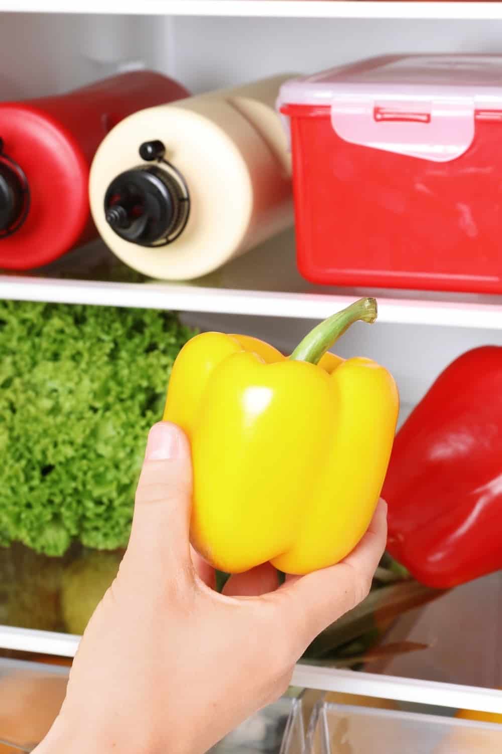 person holds a yellow bell pepper