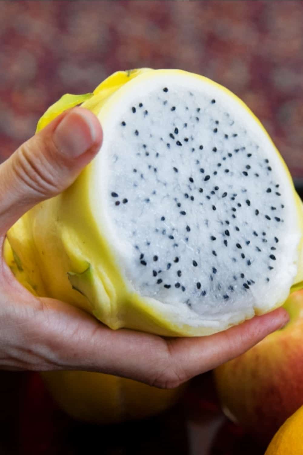 la mujer sostiene una pitaya en la mano