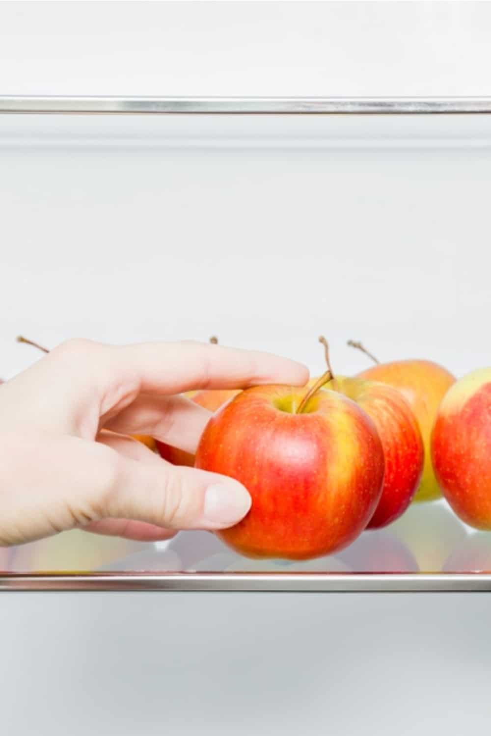 mujer sacando manzanas de la nevera