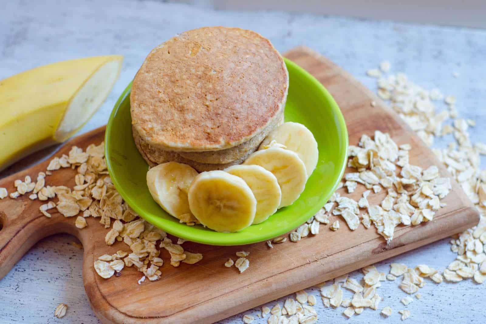 Breakfast oatmeal pancakes with banana on wooden board