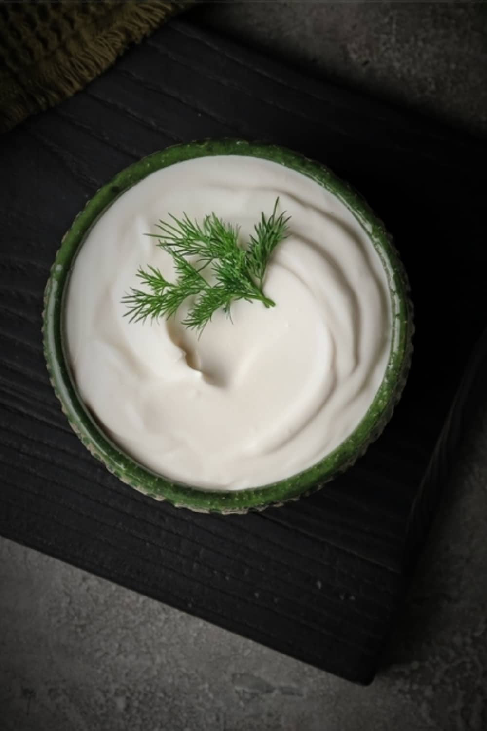 Sour Cream in einer grünen Schale auf dem Tisch