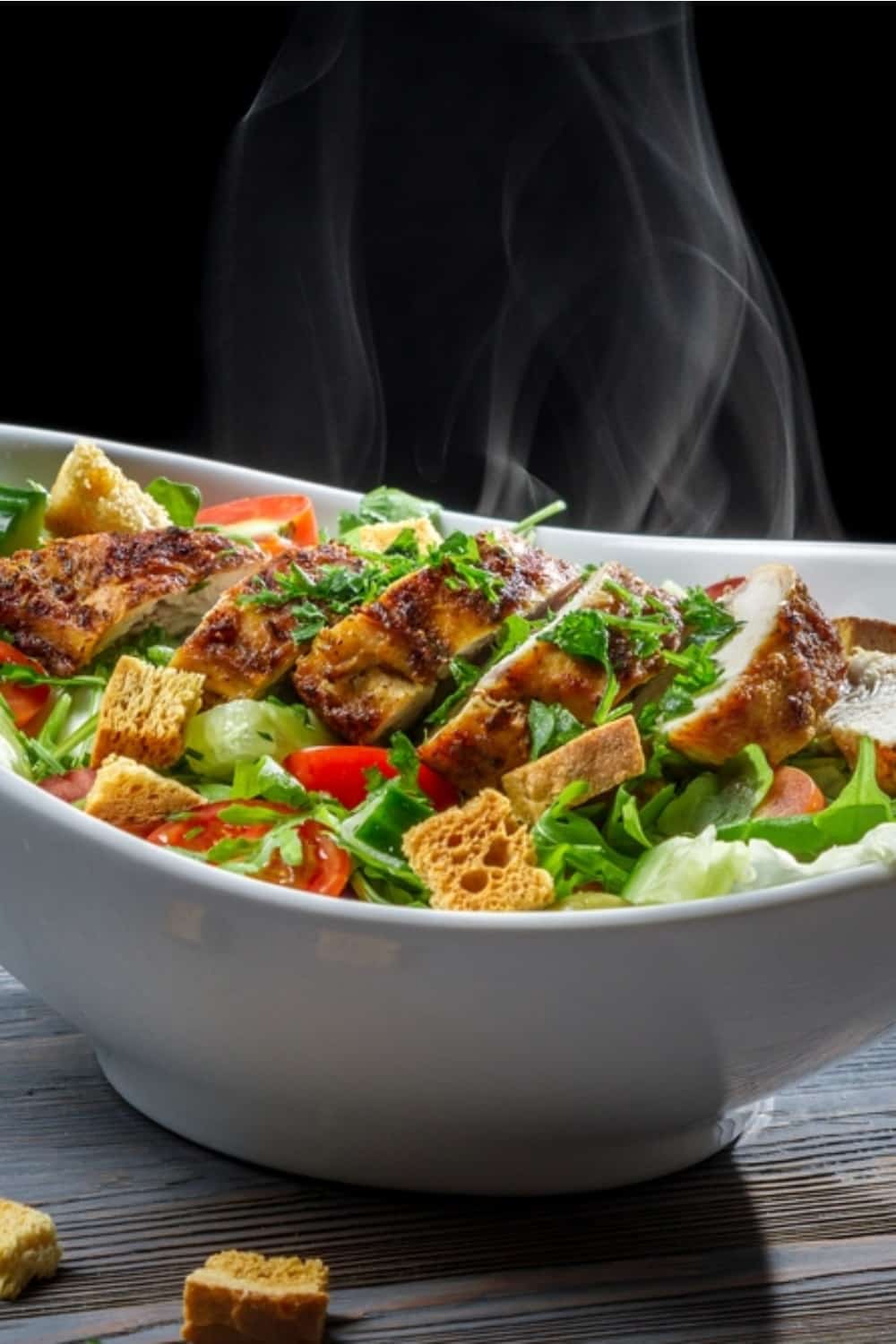 Caesar salad with hot chicken and fresh vegetables