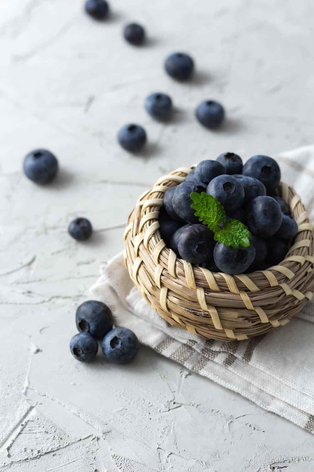 Sweet blueberries in wicker basket on the towel