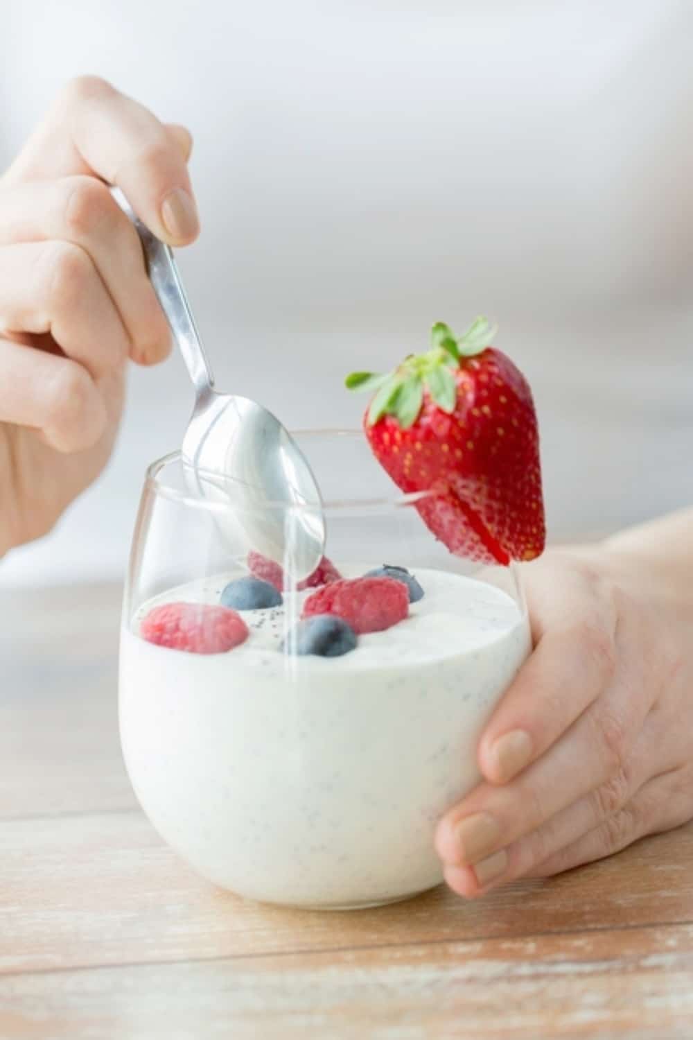 woman eating yogurt with strawberries