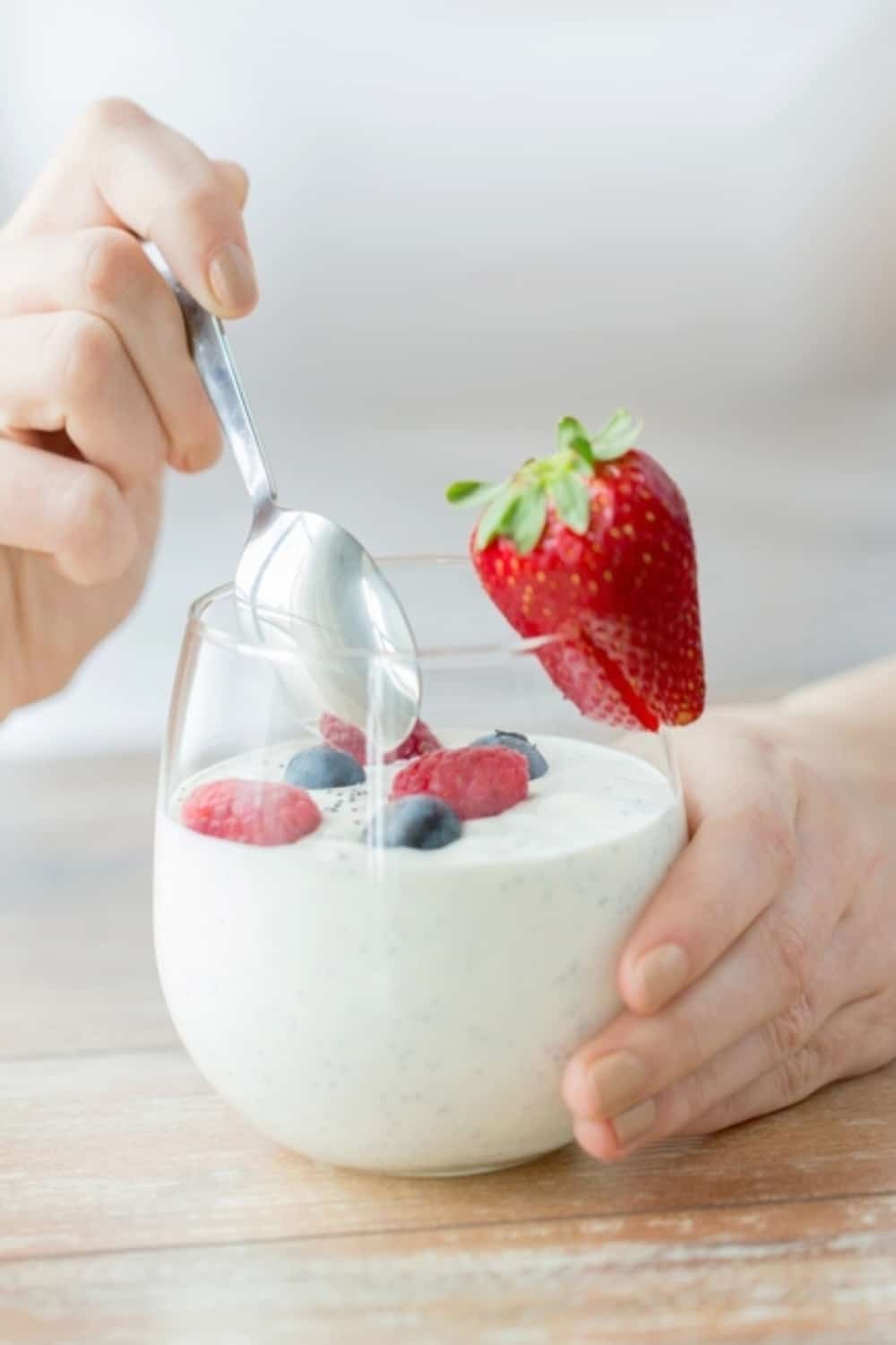 mujer comiendo yogur con fresas