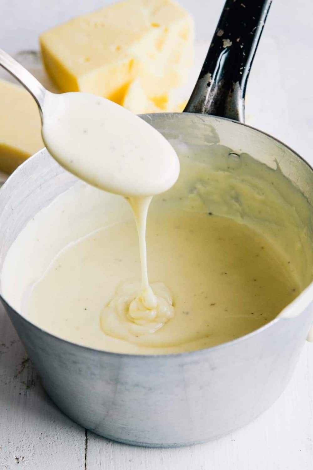 femme avec une cuillerée de mélange de concentré de roux au fromage