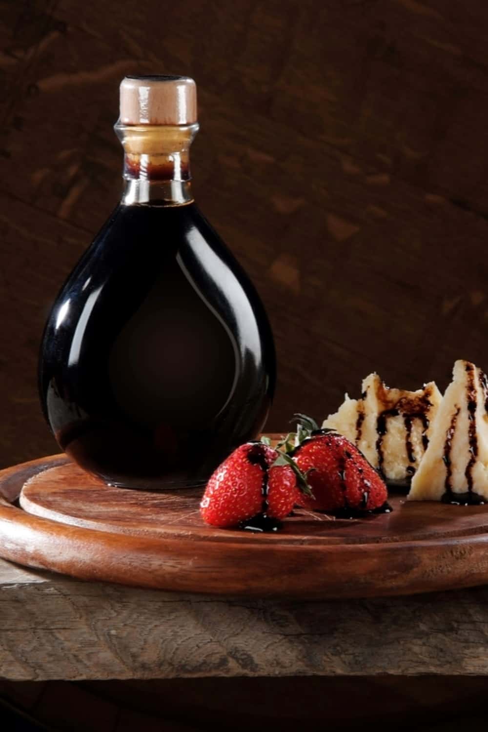 Vinaigre balsamique dans une bouteille sur un socle en bois