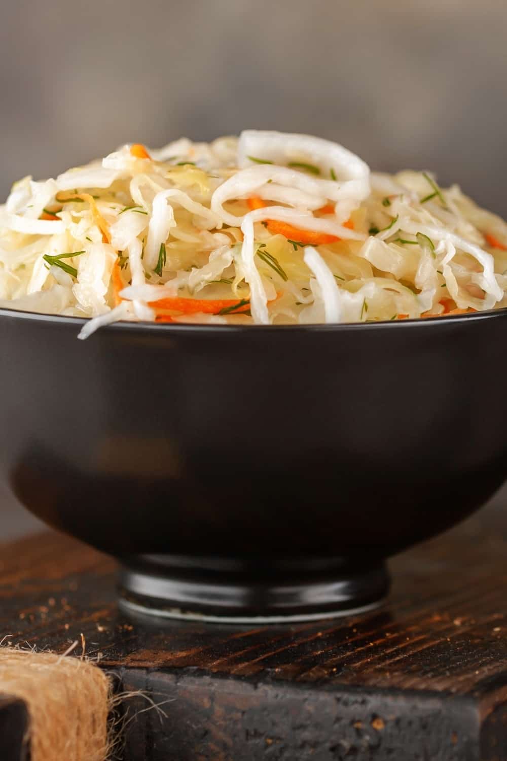 Cabbage salad coleslaw in a bowl on a cutting board