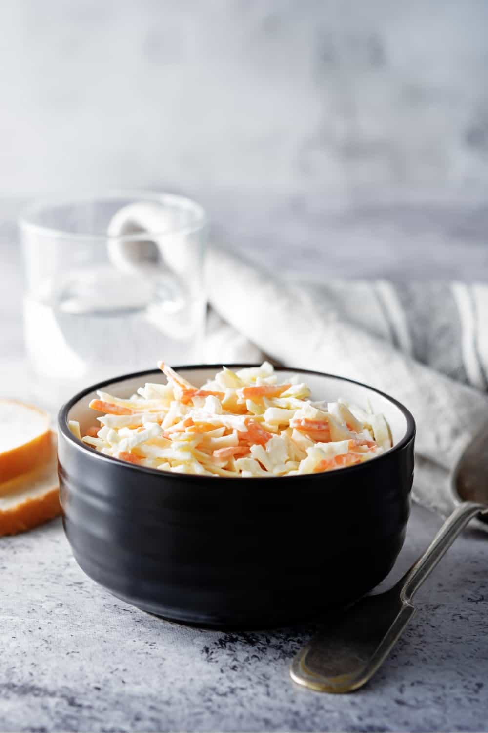 Salada de repolho, salada de couve e cenoura com molho de iogurte grego numa tigela.