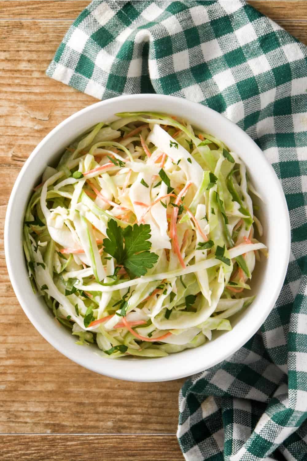 Salada de repolho numa tigela branca sobre uma mesa de madeira