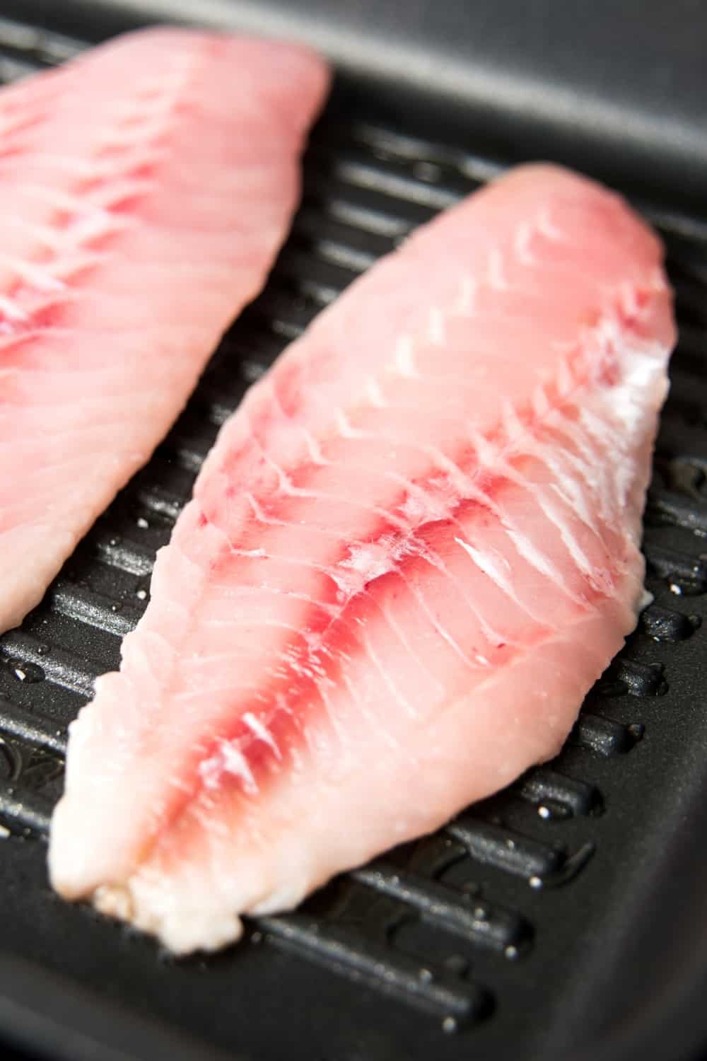 Filets de poissons de roche dans une plaque en fonte d'aluminium