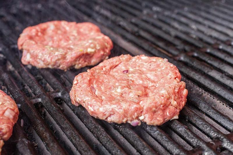 Pressing Burgers While Grilling
